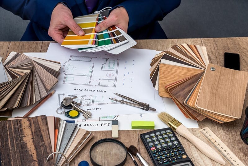 Interior designer looking over samples as they work on blueprints